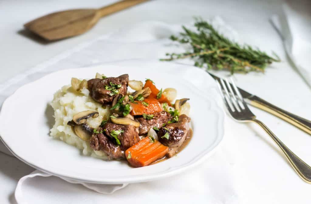 Beef Bourguignon: slow-cooked beef stew served with carrots, mushrooms, and mashed potatoes. Recipe via MonPetitFour.com