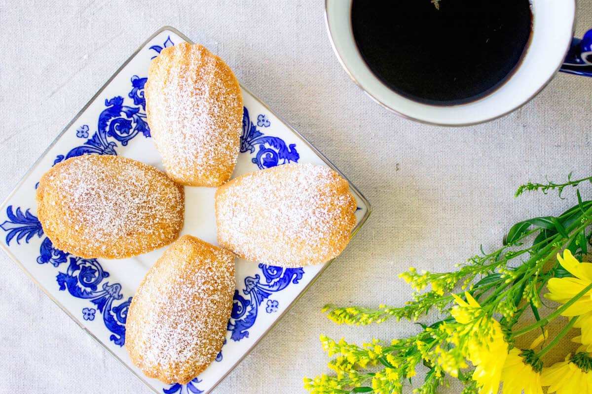 Madeleine cookies on a plate with coffee