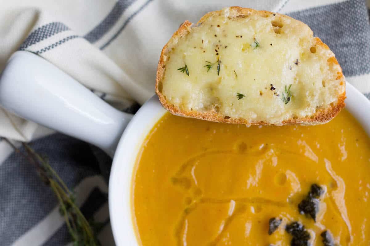 instant pot butternut squash soup recipe in a bowl with a gruyere crouton on top