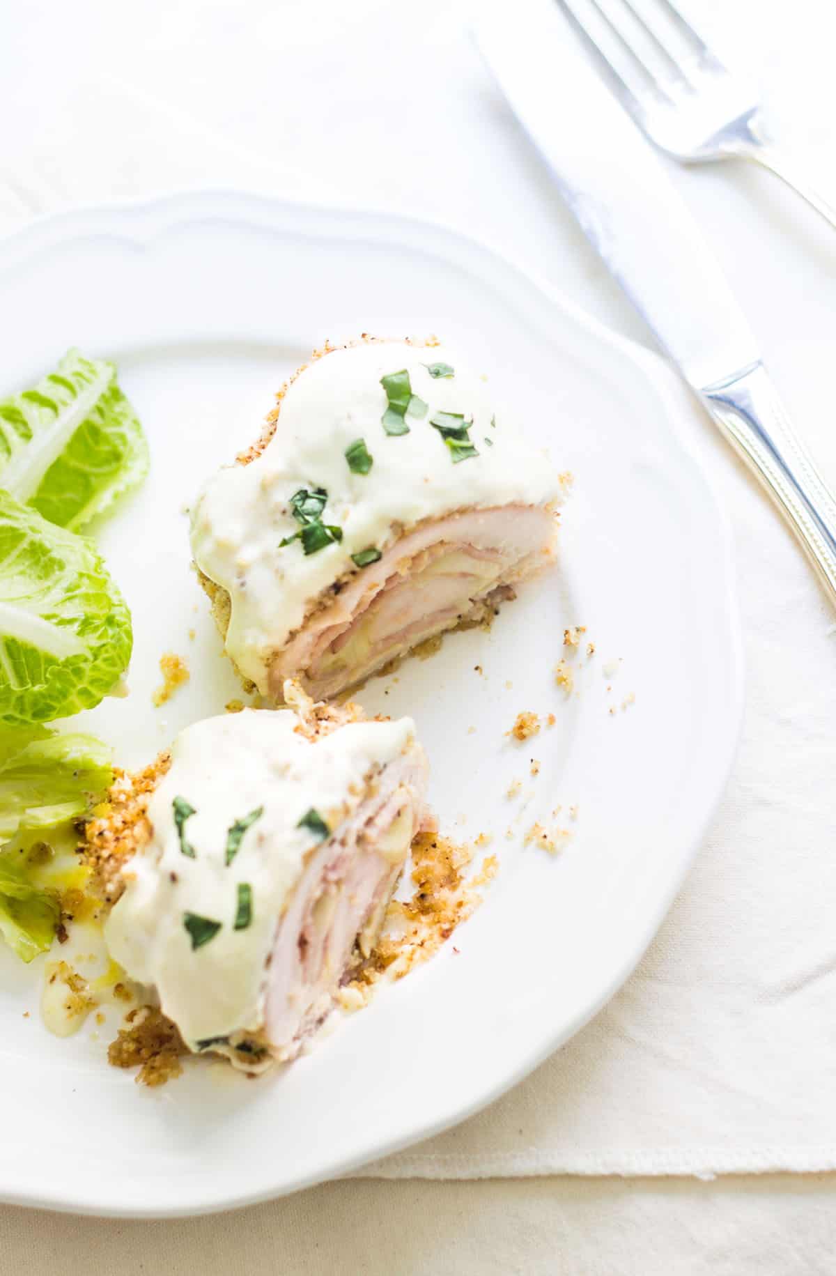 Chicken Cordon Bleu: an easy and quick French dinner! This classic is made with breaded chicken stuffed with ham and cheese. Topped with a dijon cream sauce. Recipe via MonPetitFour.com