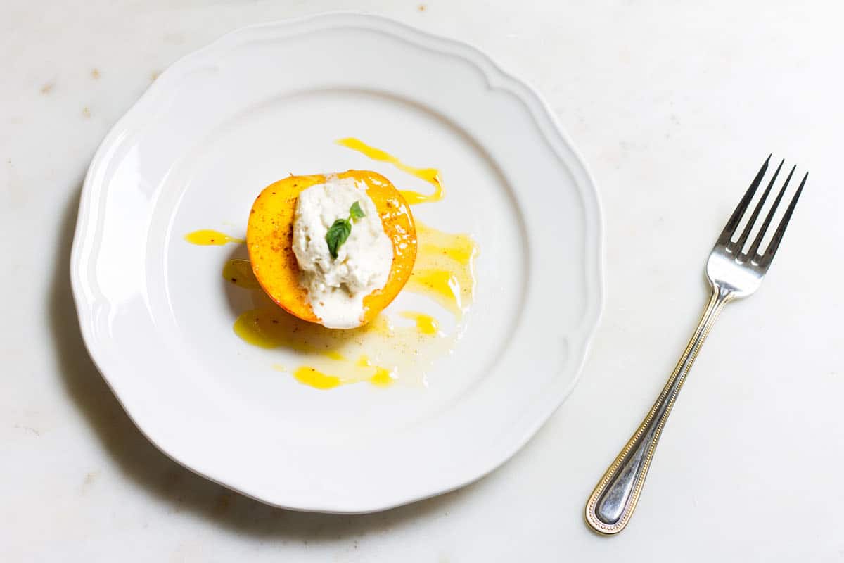 Baked Peaches with Cream: a quick and easy summer dessert made with ripe peaches and freshly whipped cream. A French recipe known as pêches rôties. Recipe via MonPetitFour.com