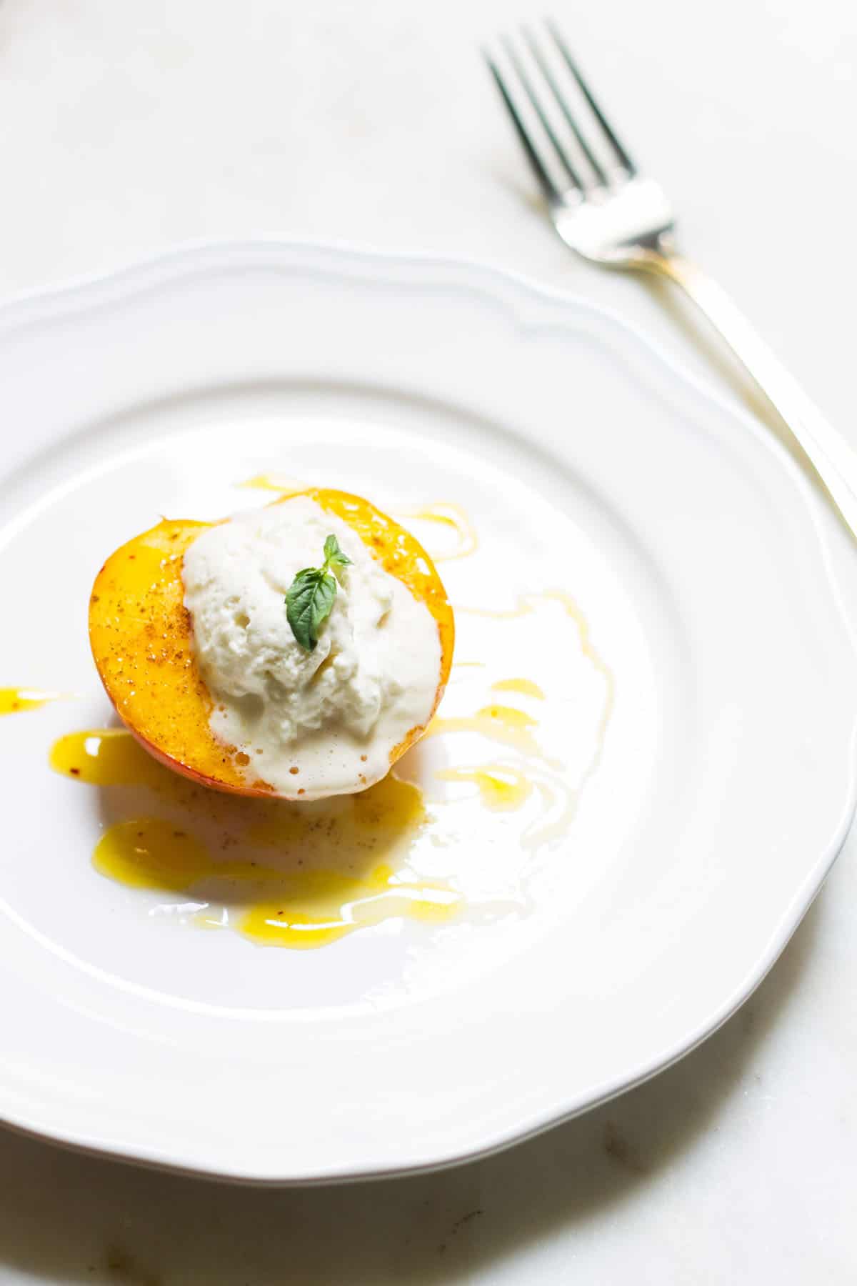 Baked Peaches with Cream: a quick and easy summer dessert made with ripe peaches and freshly whipped cream. A French recipe known as pêches rôties. Recipe via MonPetitFour.com
