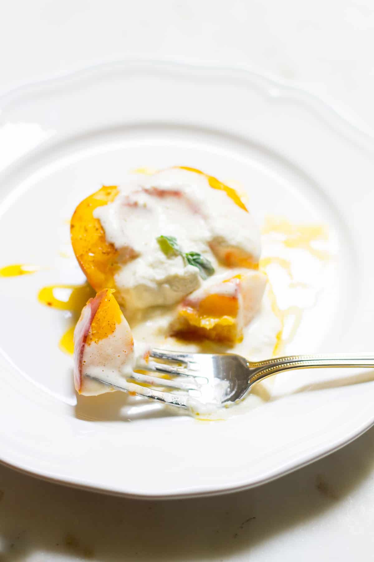 Baked Peaches with Cream: a quick and easy summer dessert made with ripe peaches and freshly whipped cream. A French recipe known as pêches rôties. Recipe via MonPetitFour.com