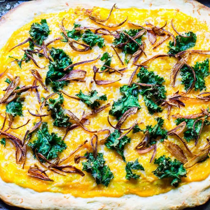 Butternut Squash Pizza: a fall pizza made with butternut squash sauce, gruyere cheese, crispy kale, and crispy shallots all on a homemade pizza crust. Recipe via MonPetitFour.com