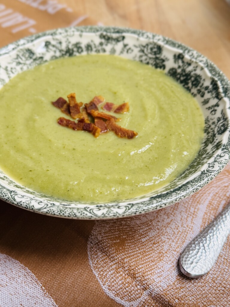 broccoli soup in a bowl with crispy bacon bits on top