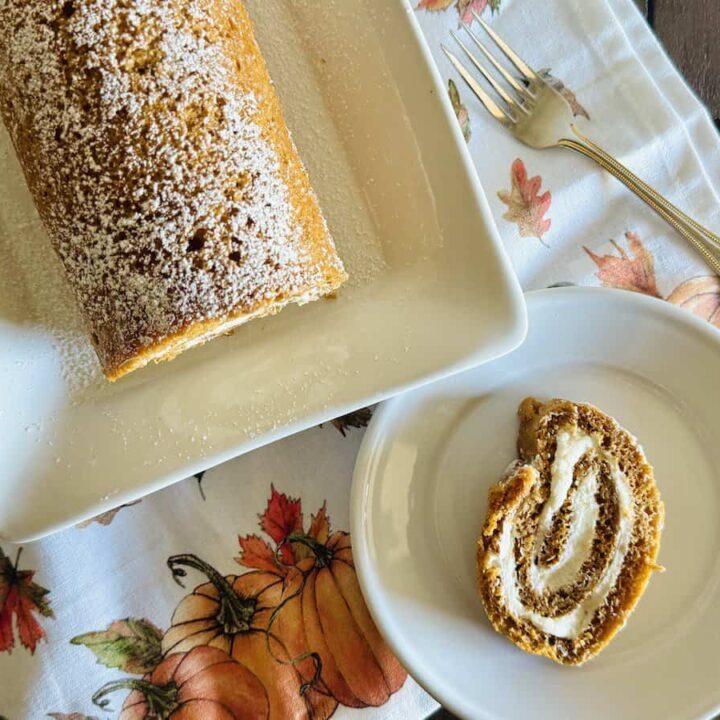 pumpkin roulade slice on a plate next to cake