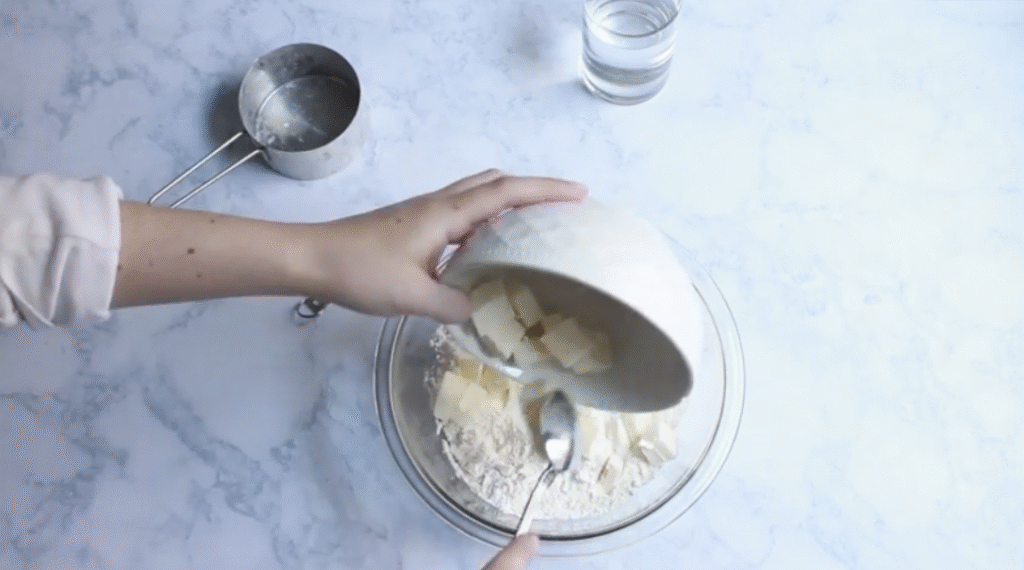 rough puff pastry ingredients of butter being mixed into flour