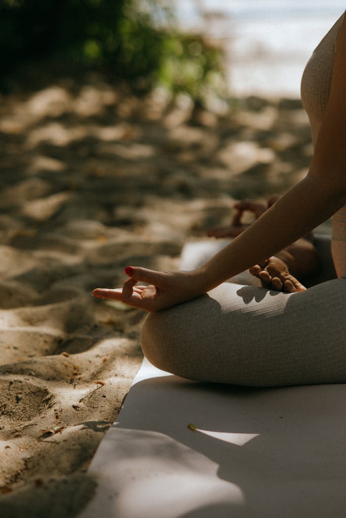 A peaceful scene of meditative yoga practice on a sandy beach.