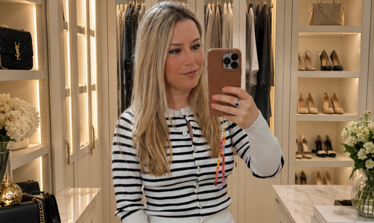 beeta wearing a striped cardigan and white maxi skirt in a dressing room
