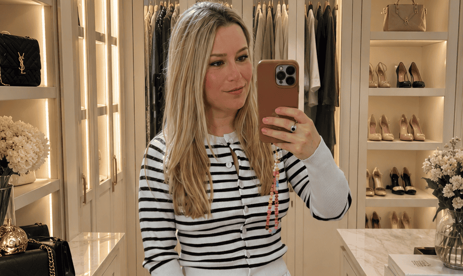 beeta wearing a striped cardigan and white maxi skirt in a dressing room